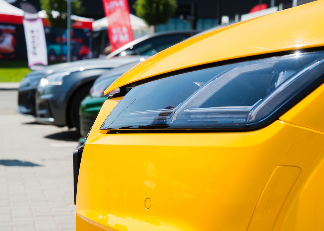 Mastering the First Impression: Your intriguing post title goes here Vibrant yellow car headlight close-up in a sunny outdoor parking lot.